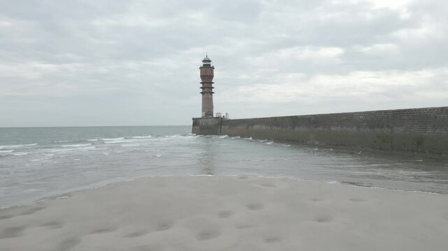 Survol au raz du sable de la plage de Dunkerque avec vue sur le feu de Saint Pol
