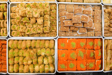 Colorful trays of baklava, a popular, Middle Eastern, layered pastry dessert made of filo pastry, filled with chopped nuts, and sweetened with syrup or honey.