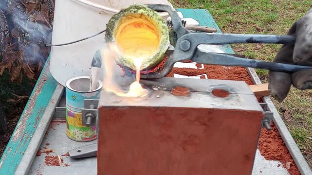 fl&uuml;ssiges Messing wird aus Grafittiegel in Form gegossen