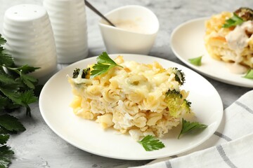 Tasty pasta casserole with cheese and broccoli served on grey table, closeup