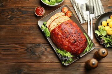 Delicious turkey meatloaf with vegetables served on wooden table, flat lay. Space for text