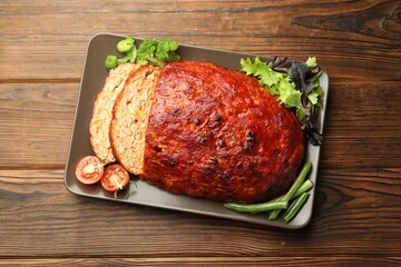 Delicious turkey meatloaf with vegetables on wooden table, top view