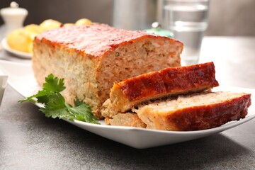 Delicious baked turkey meatloaf with parsley on grey table, closeup