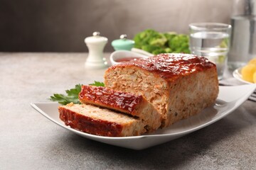 Delicious baked turkey meatloaf served on grey table, closeup