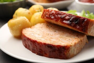 Delicious baked turkey meatloaf and potatoes on table, closeup