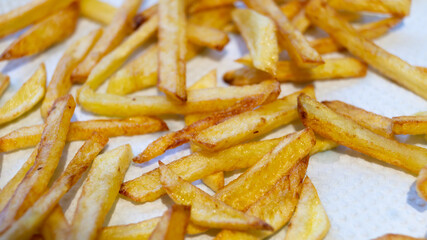 French fries on a white background close-up. Fried potatoes cut into strips