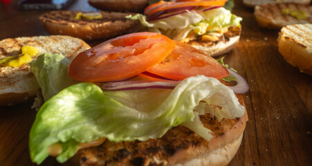 Tomato, lettuce, onion on a burger bun. Various vegetables stacked on a burger bun