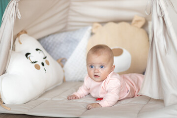 Naklejka premium Baby Lying on Soft Mat Looking at Camera in Cozy Room