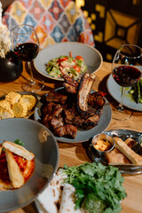 Yummy eastern cuisine served in the restaurant. Georgian food. Eastern food. Grilled lamb meat, salad, grilled corn, appetizers, red wine