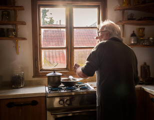 old man in kitchen cooking some food 