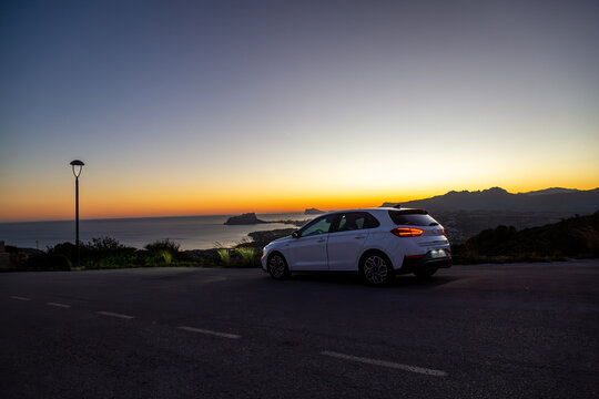 Hyundai i30 along a quiet road by the Spanish coast at sunset, Image shows the white i30 in the final moments of sunlight on a hill overlooking Moraira