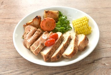 grilled slice chicken steak dressing gravy sauce with lettuce and boiled potato couple corn on plate 