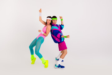 Vibrant young couple engaging in a dynamic dance routine, showcasing retro style with bold athletic wear