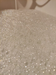 Warm water is filling bathtub, creating abundant soap foam, perfect for a relaxing bath on valentine's day spa copy space