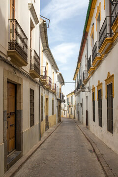 Fototapeta Empty street between houses in Cordoba, Spain.