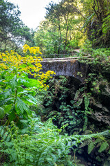 Hiking trail on a bridge along levada Caldeirao Verde (irrigation canal) in the island of Madeira, Portugal