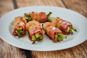 bacon wrapped green beans served on a plate with a green napkin