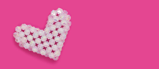 Shiny heart figurine made from square acrylic beads on a magenta background. Banner with copy space.