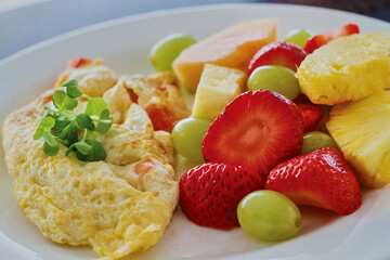 classic ham and cheese omelet with a side of fresh fruit