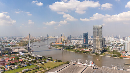 Naklejka premium Aerial panorama of downtown Bangkok, the capital city of Thailand, with view of modern skyscrapers by Chao Phraya River and a beautiful urban skyline ~ Riverside cityscape of Bangkok on a sunny day