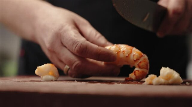 Male Chef Slicing Lobster Tail as He Prepares For Cuisine Meal