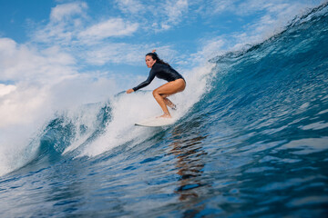 Female surfer on surf board during surfing. Surfer woman and ocean wave