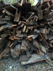 Old wooden planks stacked in a heap on the ground.