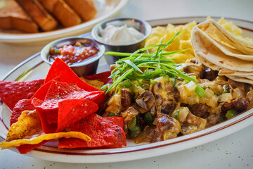 Mexican breakfast platter with eggs, hash, salsa, and sour cream