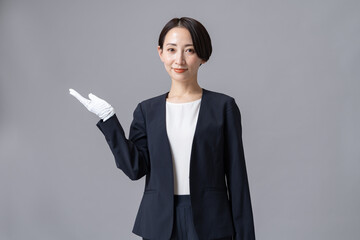  白い手袋をつけスーツを着た女性