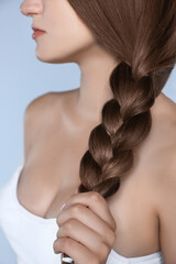 Attractive woman with beautiful hair in mocha mousse shade on grey background, closeup. Trendy...