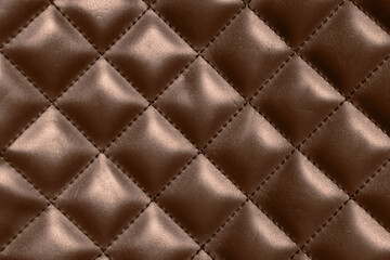 Leather surface in mocha mousse shade with diamond pattern, closeup. Trendy color of 2025 year