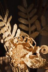 Flower made of straw on a dark background. The flower is illuminated by the sun. Straw weaving. Small depth of field. 