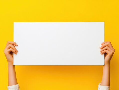 Blank White Sign Held by Hands Against Vibrant Yellow Background