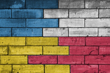 colourful painted big flag of ukraine and flag of poland on a massive old brick wall background. concept