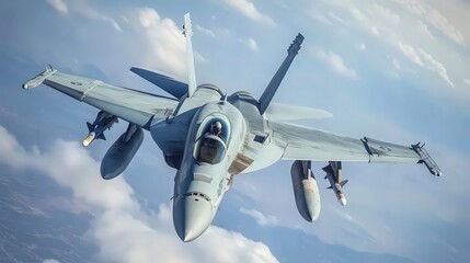 A military jet fighter flies in a vast blue sky dotted with clouds showcasing its powerful form