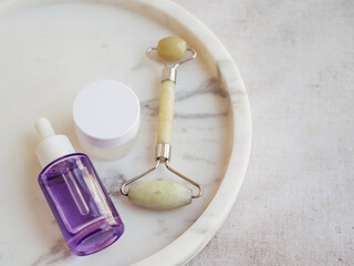 Bakuchiol serum and jade roller in marble tray 