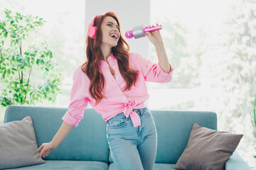 Photo of pretty young woman sing microphone wear pink shirt modern bright interior apartment indoors