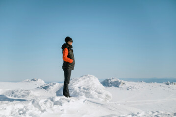 Hiker woman hiking in the high winter snowy mountain with stunning view 