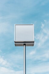 A blank sign on a pole against a bright blue sky