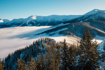 Winter hiking to Sina in Low Tatras National park near jasna is full of beautiful views. Sunset in Slovakia mountains with Chopok peak.
