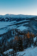 Winter hiking to Sina in Low Tatras National park near jasna is full of beautiful views. Sunset in Slovakia mountains with Chopok peak.