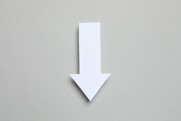 Paper arrow on gray background, top view