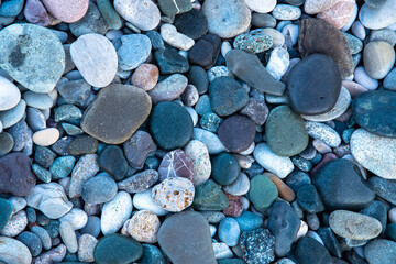 Smooth round wet pebbles texture background. Pebble sea beach close-up