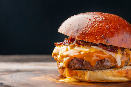 This mouthwatering cheeseburger features a perfectly cooked patty topped with crispy bacon and oozy melted cheese, all nestled within a golden brioche bun.