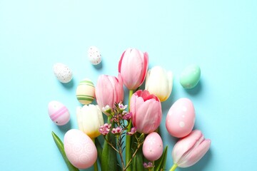 Easter decor concept. Top view photo of colorful eggs with tulip flowers on color background