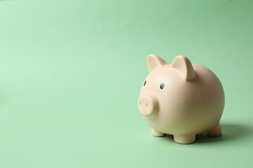 Piggy coin bank on color background for money savings, financial security or personal funds concept