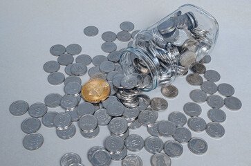 Golden Bitcoin against silver coins spilling from glass jar. Symbol integration of cryptocurrency...