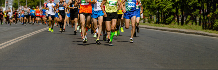 athletes race down road in colorful running gear, showcasing determination and speed in marathon event