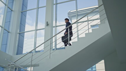 Businessman hurrying work meeting walking down staircase office environment. © stockbusters
