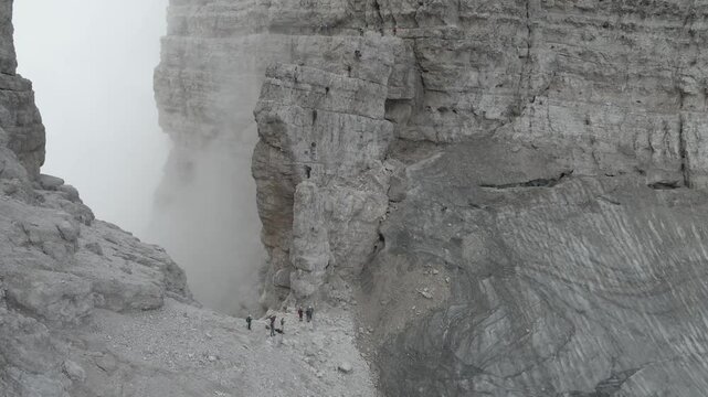 Aerial footage of Bocca d'Armi, Torre di Brenta, and Cima di Molveno on via ferrata Bocchette Centrali in Brenta Dolomites, withsteep ridges, dramatic cliffs, and climbers navigating exposed paths.